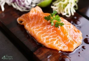 Fresh salmon sashimi slices served with wasabi and soy sauce, showcasing the delicate texture and vibrant color of the fish.