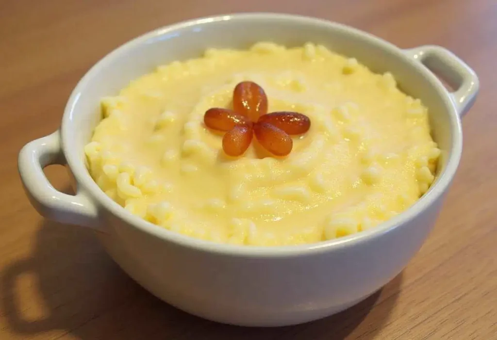 Creamy rice pudding topped with cinnamon and raisins, served in a white bowl.